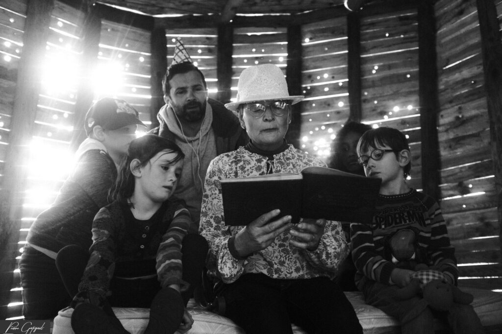 Adulte lisant un livre à des enfants assis ensemble