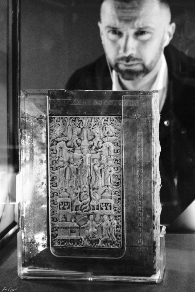 Livre ancien exposé sous vitrine, homme en arrière-plan