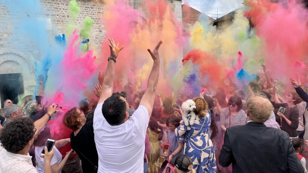 Foule lançant des poudres colorées en plein air
