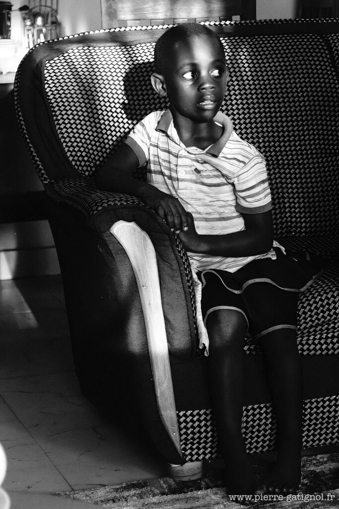 Jeune enfant assis dans un fauteuil, regard tourné de côté