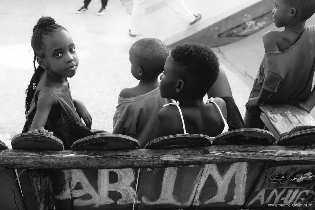 Enfants assis sur un banc, l’un regarde l’objectif