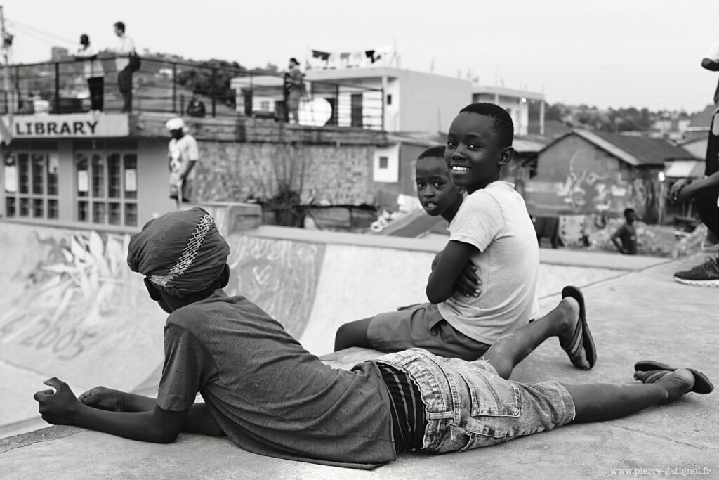 Deux enfants assis et allongé sur une dalle en extérieur