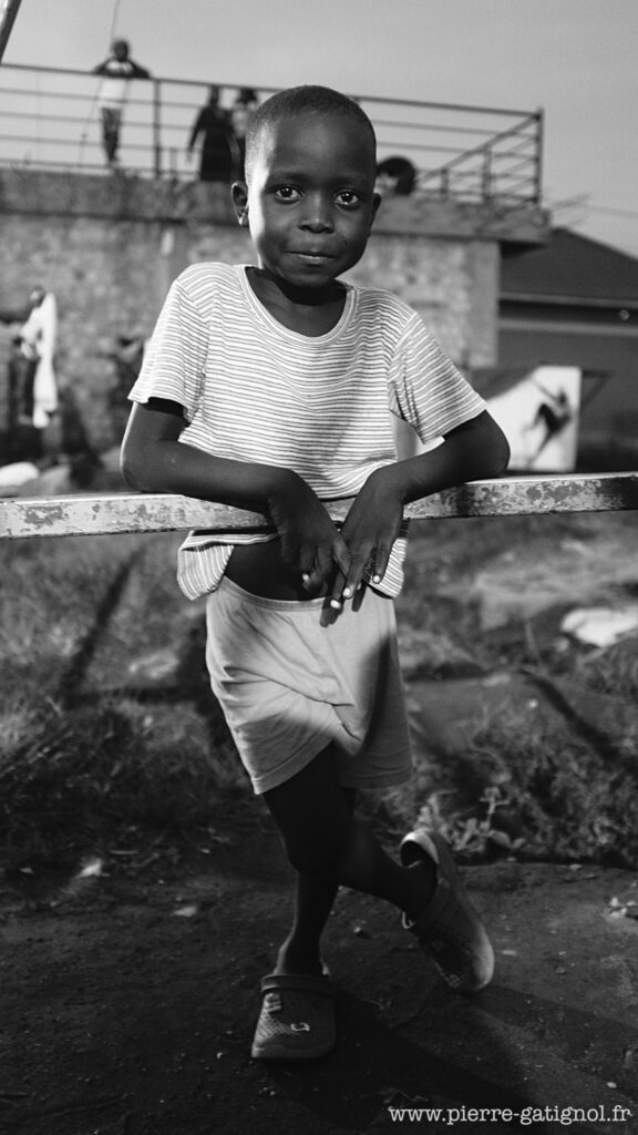 Enfant debout appuyé à une rambarde métallique