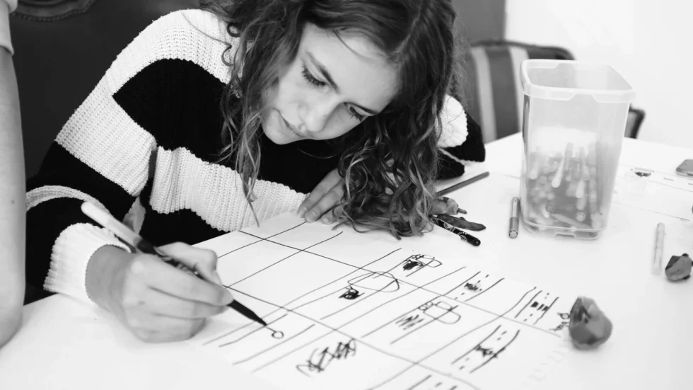 Enfant concentré sur un dessin en atelier créatif