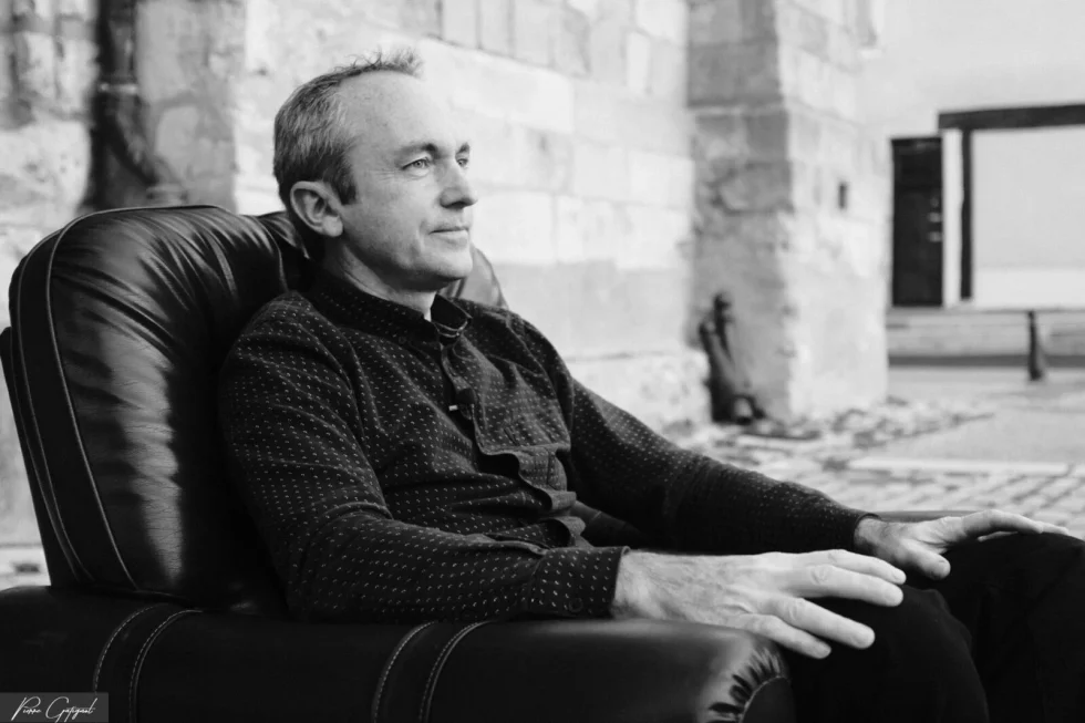 Homme assis dans un fauteuil en extérieur, portrait en noir et blanc